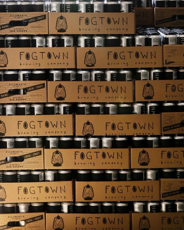 Stacked cardboard cases printed with the Fogtown lantern