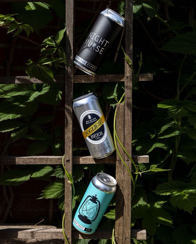 Night Nurse, Foglight and Maine Coast cans tucked into a vine-covered trellis