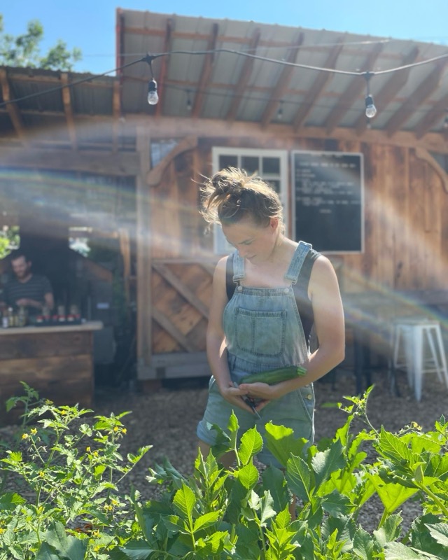 A gardener in overalls tending greens in the beer garden