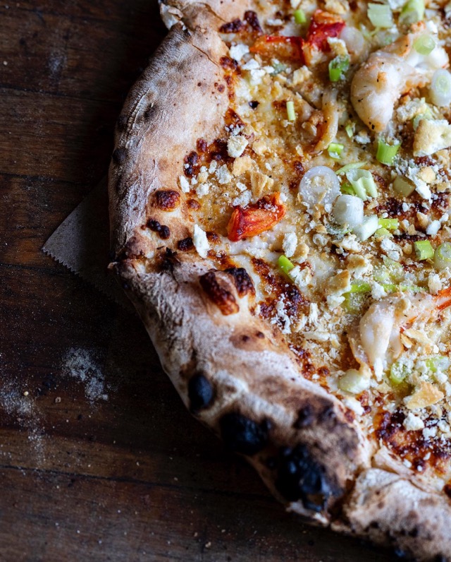 Close-up of a charred, blistered wood-fired crust